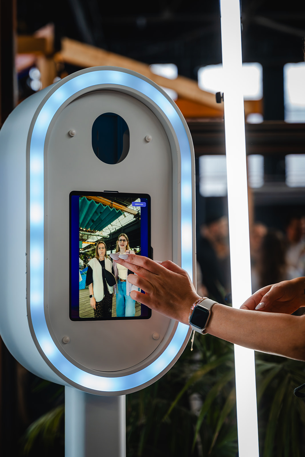 Gast bedient den Touchscreen der gebrandeten Fotobox